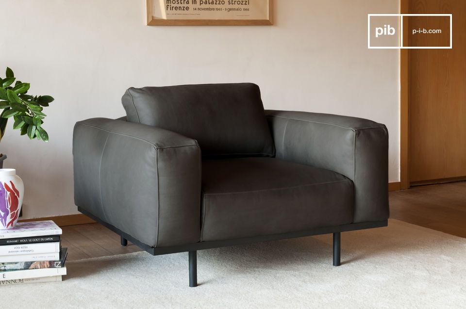 A characteristic armchair in grey leather, inspired by models from the 60s.