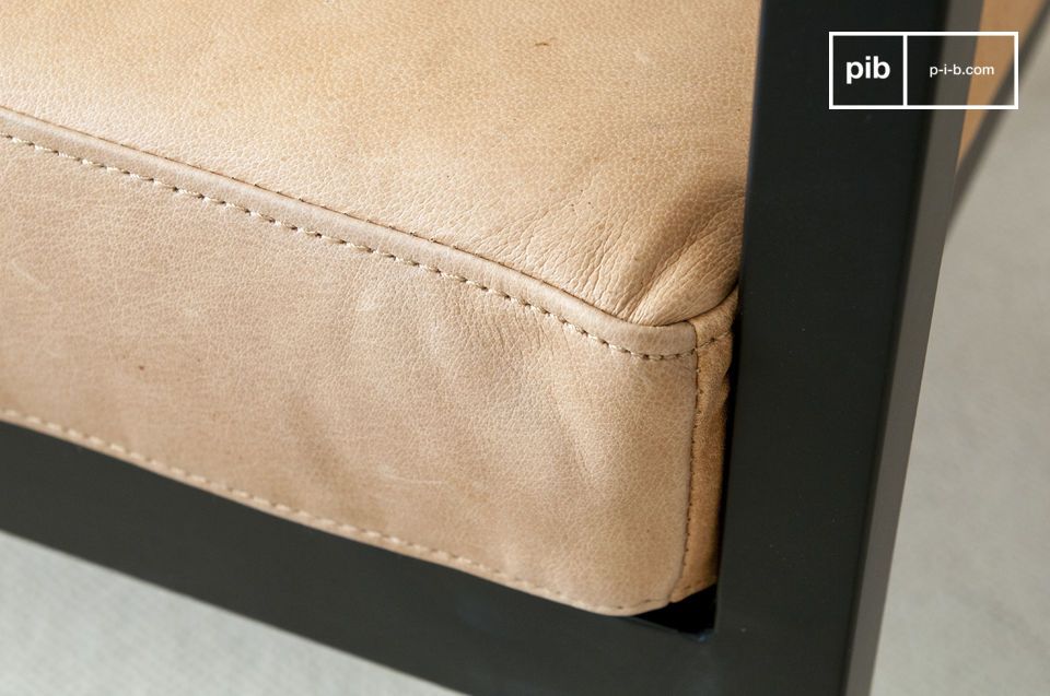 The light brown leather of the armchair and its pretty topstitching of the same color.