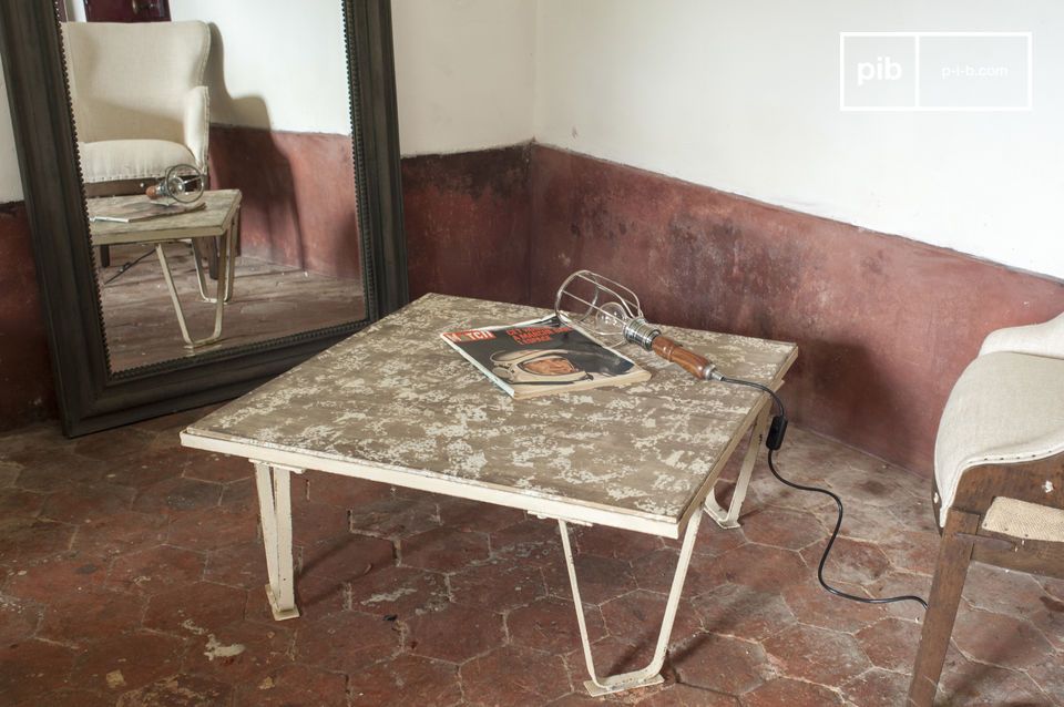 A coffee table that combines a metal structure in the manner of old workshop pallets