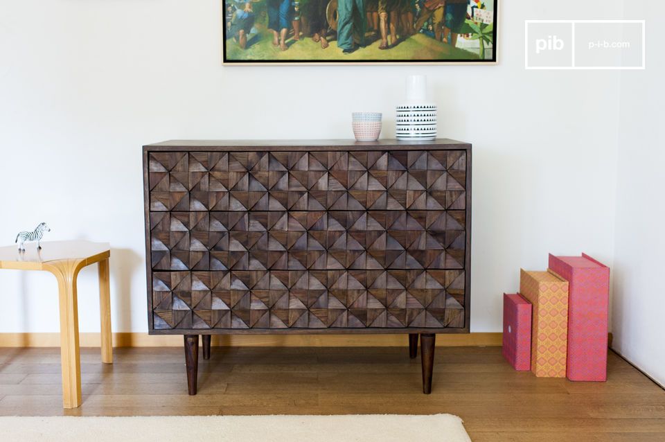 A beautiful dark wooden chest of drawers with relief.