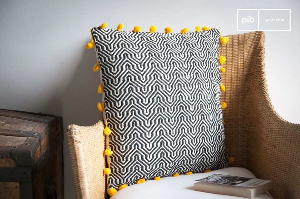 Elegant black and white cushion with yellow pompoms.