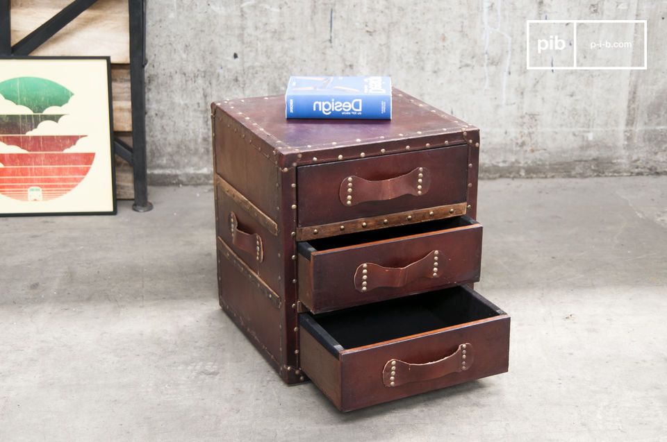 Made of wood, the chest of drawers is covered with studded leather.