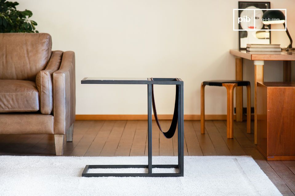 Furniture combining black veined marble top and side magazine rack.