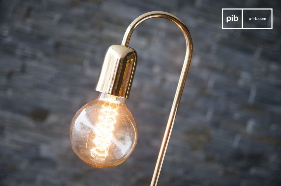 The long filament bulb is supported by a brushed golden brass rod.