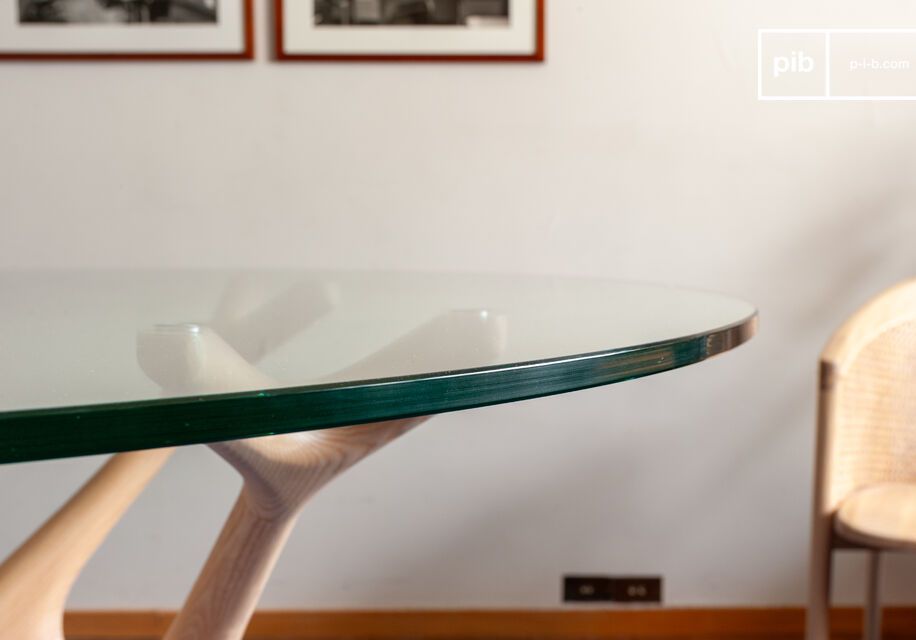 It combines the transparency of a tempered glass tabletop with a sculptural base reminiscent of