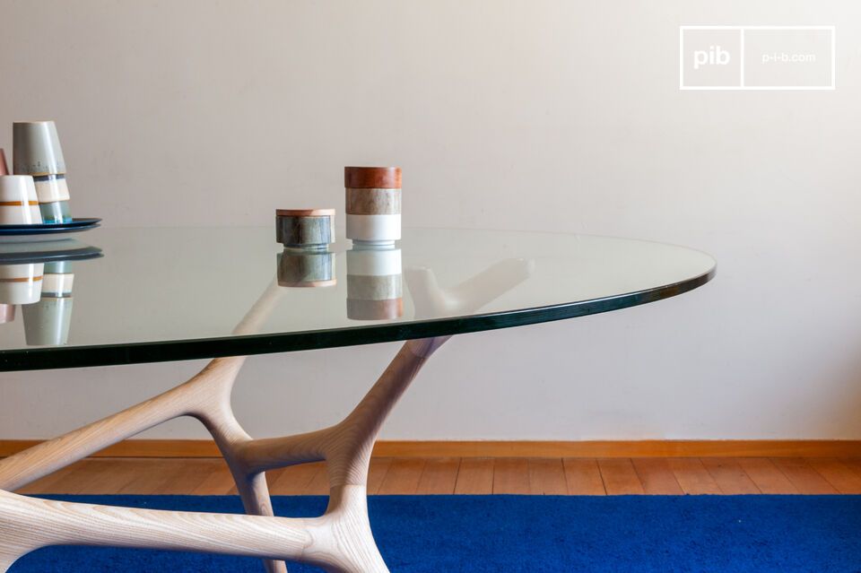 Its tempered glass tabletop rests on a sculpted base reminiscent of intertwined branches