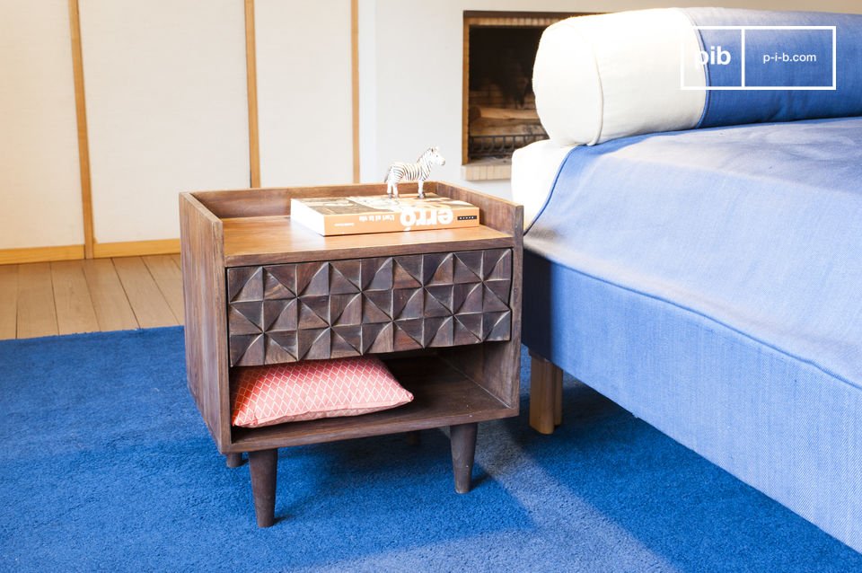 The bedside table is made of dark wood with a lighter shelf.